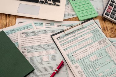 Yeni vergi formları 1040 hesap makinesi kalem defteri ve defter ahşap bir masanın üzerinde. Belgeler konsepti