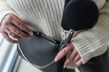 Deneyimli kız model ellerinde şık bir çanta reklamları yapıyor. Pahalı aksesuarlar kavramı
