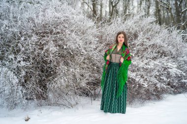 Güzel sarışın, kış ormanında poz veriyor.