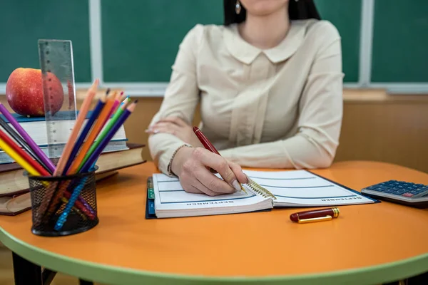 아름다운 선생님 안경을 책상에 연필로 메모지 사과를 칠판에 교실에서 — 스톡 사진