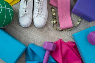 Spor topu için renkli halterler spor için kum spor ayakkabıları sakızları ve geniş zemine yayılmış küplerle. Spor konsepti. Spor malzemeleri konsepti