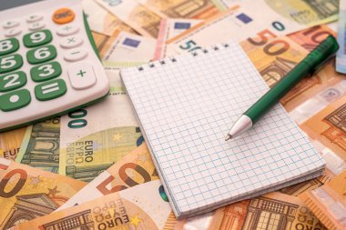 Hesap makineli boş not defteri, kalem euro faturaları. Uzayı kopyala İş konsepti. 