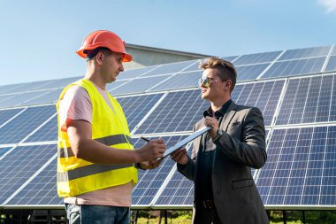 Foreman, güneş enerjisi istasyonunda fotovoltaik detay işadamı gösteriyor. yeşil enerji