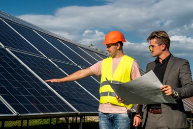 Ustabaşı ve mühendis güneş fotovoltaik panelini kontrol ve onarım sırasında çalışırlar. Yeşil enerji kavramı