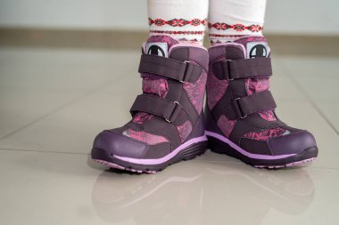 Güzel, rahat ve küçük bir çift ayakkabıyla poz veren küçük bebek. Küçük çocuk ayakkabısı konsepti