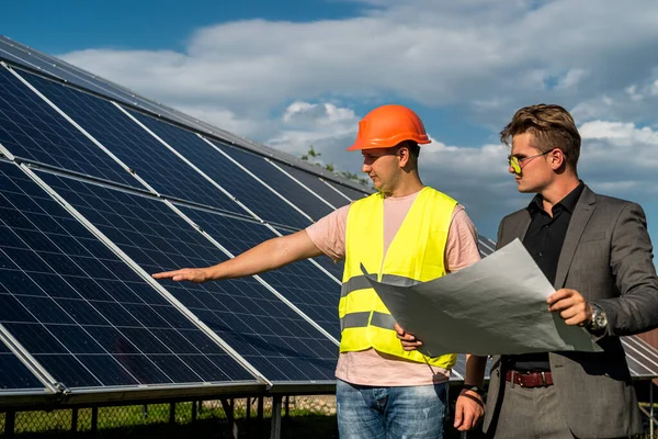 Ustabaşı ve mühendis güneş fotovoltaik panelini kontrol ve onarım sırasında çalışırlar. Yeşil enerji kavramı