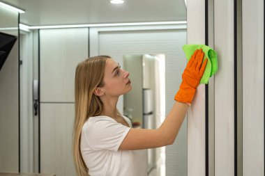 Güzel genç sarışın mutfağını temizliyor. Mutfak temizleme konsepti