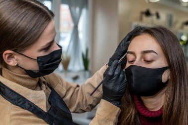 Yeni bir makyöz salgın sırasında makyaj maskesi takan genç bir müşteriyi davet etti. Salgın sırasında salonlar kavramı