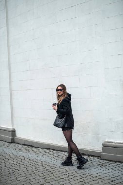 Sonbaharda eşsiz genç bir kız şehrin güzel yerlerinde mutlu bir şekilde yürüyor. Sonbahar konsepti. Şehir konsepti