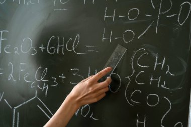 Sınıf tahtasında kimya öğretmeni yazma ve kimyasal formülü açıklama, çalışma