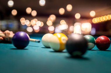 Kadın eli yeşil bilardo masasına bilardo topu doğrultuyor. Yaşam biçimi