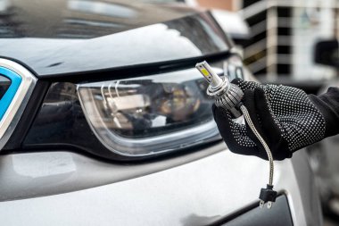  Erkek eli modern LED h7 bukb Bir arabanın far yakınında