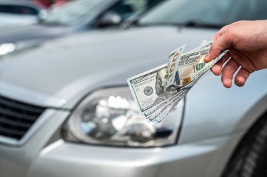 Kiralık ya da araba almak için dolar tutan adam. başarı anlaşması konsepti