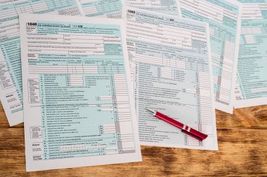 Ahşap bir masanın üzerine yerleştirilmiş güzel saplı yeni vergi formları. Belgeler konsepti