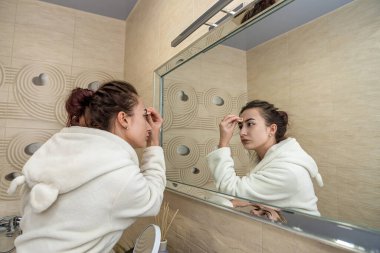 Güzel manken banyoda çekim yapmaya ve makyaj yapmaya hazırlanıyor. Makyaj konsepti.