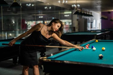Güzel bayan bilardo maçını kazanmak için kolay atış yapar. Hoş bir boş zaman.
