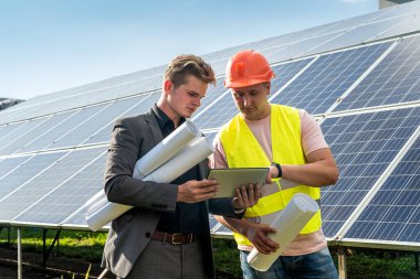 İşçi, patronuna güneş panelleri kurulumunun, yeşil enerji konseptinin,