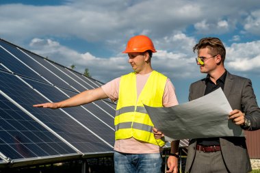 Çalışan ile birlikte kurulum güneş paneli projesini tartışan yönetici