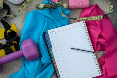 Dambıl şeklinde güzel spor aletleri ve dambıllar yerde yatıyor. Arka planda spor ekipmanı kavramı