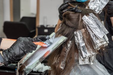 Bir salgın sırasında, kabinde maske takmış güzel siyah saçlı bir kız resmediliyor. Salonda salgın sırasında saç boyama konsepti