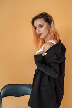 Genç ve gelecek vaat eden seksi iş kadını şeftali arkaplanda kameranın önünde çılgınca poz veriyor. Şeftali arka planda bir kadının portresi.