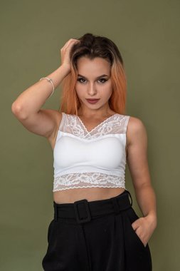 Yeşil arka planda poz veren zarif yeni bir bayan imajı takınan güzel bir genç kız. Tek renkli arkaplanda kadın portresi kavramı