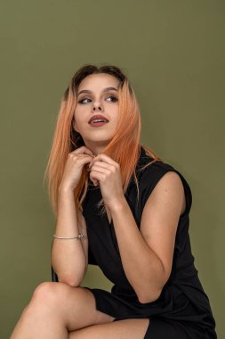 Makyajlı, bakımlı, şık giyinmiş bir kız sağlam bir arka planda poz veriyor. Arka planda güzel bir kız kavramı