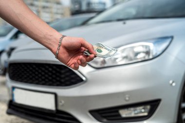 Kiralık ya da araba almak için dolar tutan adam. başarı anlaşması konsepti