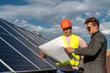 Çalışan ile birlikte kurulum güneş paneli projesini tartışan yönetici