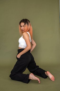 Oldukça meraklı bir genç, havalı giyinmiş, sağlam bir arka planda gösteriş meraklısı. Yeşil arka planda sevimli kız konsepti