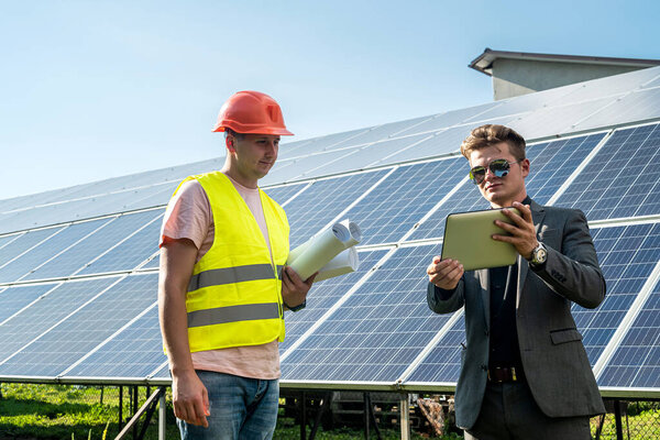 Работник и заказчик говорит о стоимости проекта на солнечные панели, экономя концепцию