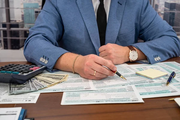ジャケットを着たビジネスマンが納税申告書を記入し表で計算します 商号及び納税様式の概念 — ストック写真
