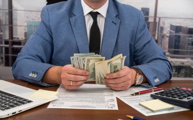 Bir stilistten takım elbiseli katı bir işadamı ofiste kendi işiyle ilgili hesaplamalar yapar. Vergi formları ve iş konsepti