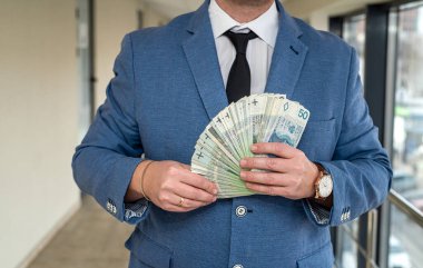 Takım elbiseli ve kravatlı, gelecek vaat eden yakışıklı bir adamda bol miktarda Polonyalı zloti bulunur. İş ve kâr kavramı