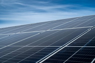 çok güzel mavi bir gökyüzünün arka planında yeni temiz enerji tasarruf eden güneş panelleri duruyor. Yeşil elektrik kavramı