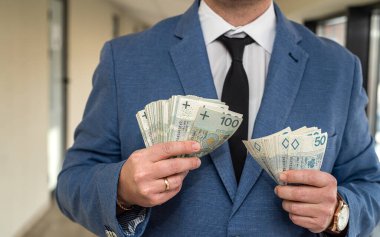 Mükemmel, kibar bir adam Polonya zlotylerini güçlü ellerinde tutar. Yüksek gelir kavramı