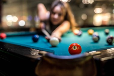 Güzel bir kadın barda bilardo oynayarak boş zaman geçirir. oyun konsepti