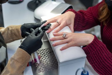 Profesyonel bir tırnak uzatma ustası salgın sırasında müşterisinin rengini seçer. Manikür kavramı