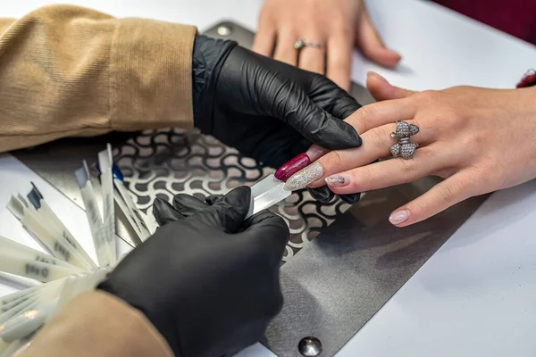 Beautiful Young Woman Working Nail Salon Offers Color Nail Polish — стоковое фото