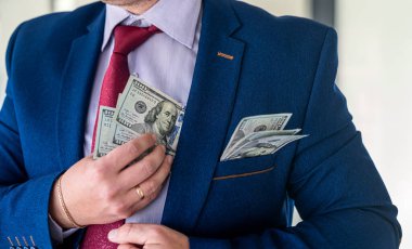 Başarılı bir anlaşmadan ya da rüşvetten sonra cebine dolar koyan bir iş adamı. bozuk kavram