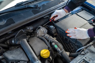 Motoru açık kaputta tamir etmek veya kontrol etmek için İngiliz anahtarını kullanarak mekanik eli kapat  