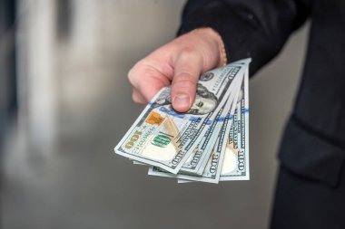 İş adamı bize bir dolarlık para veriyor. Tasarruf ve finans kavramı