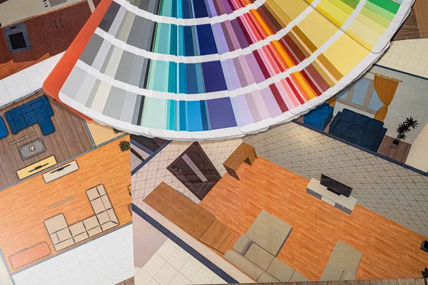 in the photo printing room with a color design, a fan with colors lying on the table, a plan for repairing the house. Color selection concept for room design