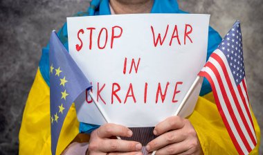 Adamın elinde Ukrayna 'daki savaşı durdurmak için bir poster var. Bir teorisyen olarak Rusya 'nın tamamen izole edilmesi