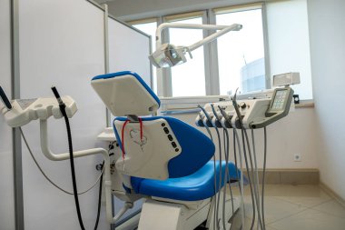 Modern klinik diş dolabında yeni mavi dişçi koltuğu. Sağlık Hizmetleri
