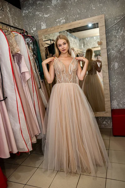 Charming Woman Measures Beautiful Evening Dress Clothing Store Concept Buying — стоковое фото