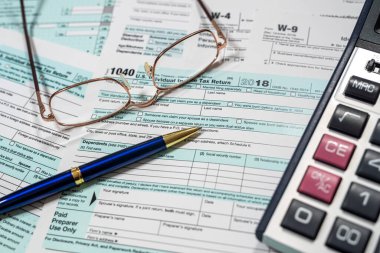 ABD vergi formları 1040 kalem hesap makinesi, gözlük ve iş mali konsepti ile birlikte. Finansal konsept. Vergi zamanı.