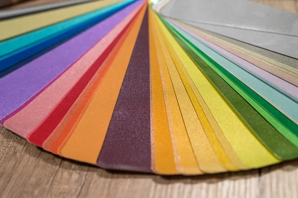 Color stack of test samples for paint or fabric in rainbow spectrum colors on the table. The concept of test samples in different colors