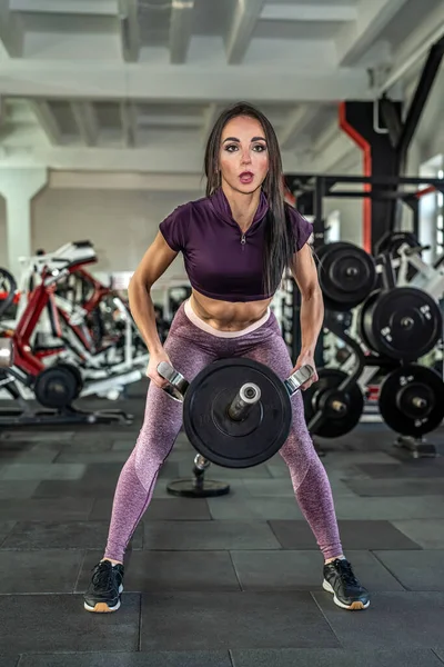 fitness ve spor salonundaki uygun trenler gibi lüks ve seksi figürlü genç, koyu renk saçlı bir antrenör. Sağlıklı yaşam tarzı kavramı