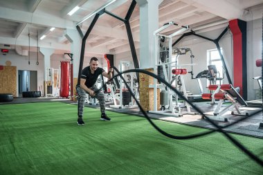 Sportif kıyafetler giyen yakışıklı bir antrenör müşterilerini sağlıklarını iyileştirmek için eğitir. Sağlıklı yaşam tarzı kavramı.